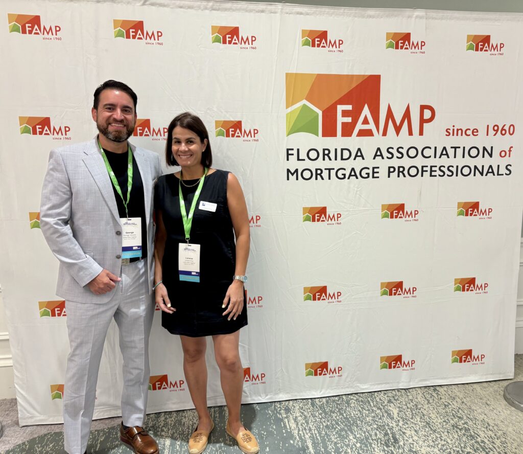 George Nevada and Lorena Diaz of Lima One Capital standing in front of signage for the Florida Association of Mortgage Professionals (FAMP) Convention. 