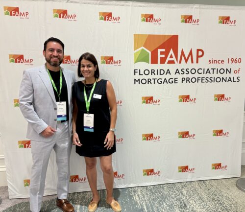 George Nevada and Lorena Diaz of Lima One Capital standing in front of signage for the Florida Association of Mortgage Professionals (FAMP) Convention.