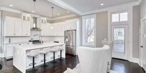 Interior shot of an all white kitchen with stainless steel appliances